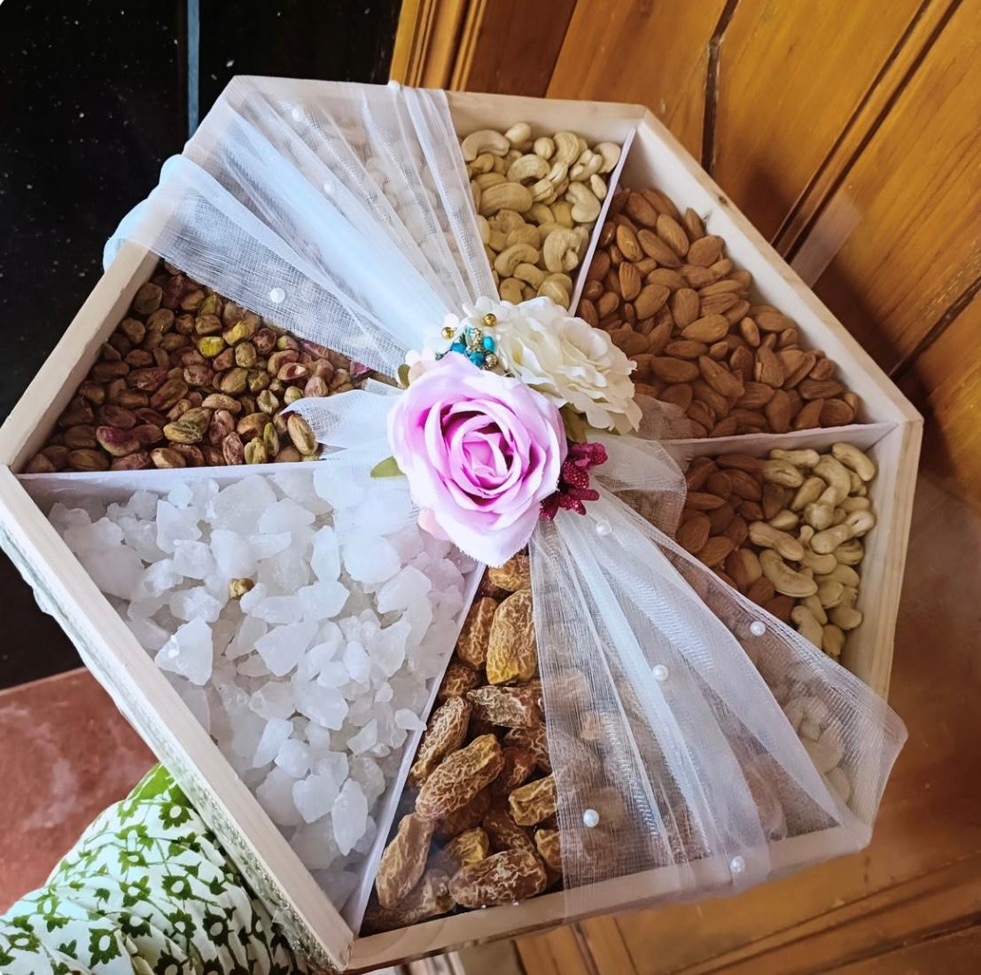 Hexagonal wooden box with assorted nuts and coconut candy